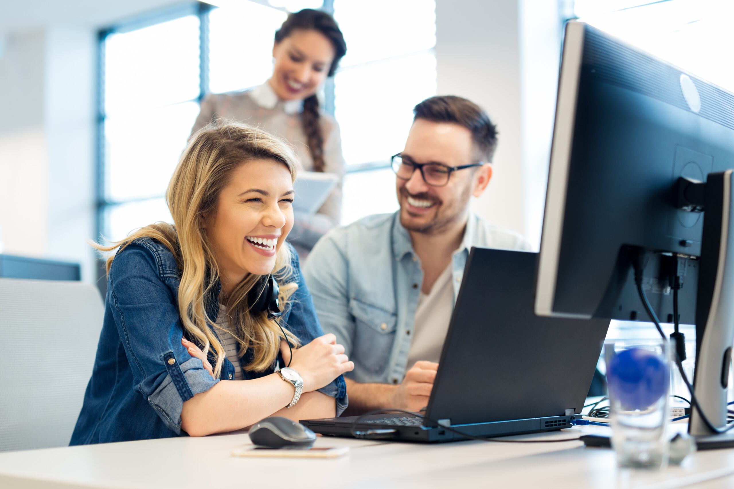 employees smiling and looking at an ecard on computer