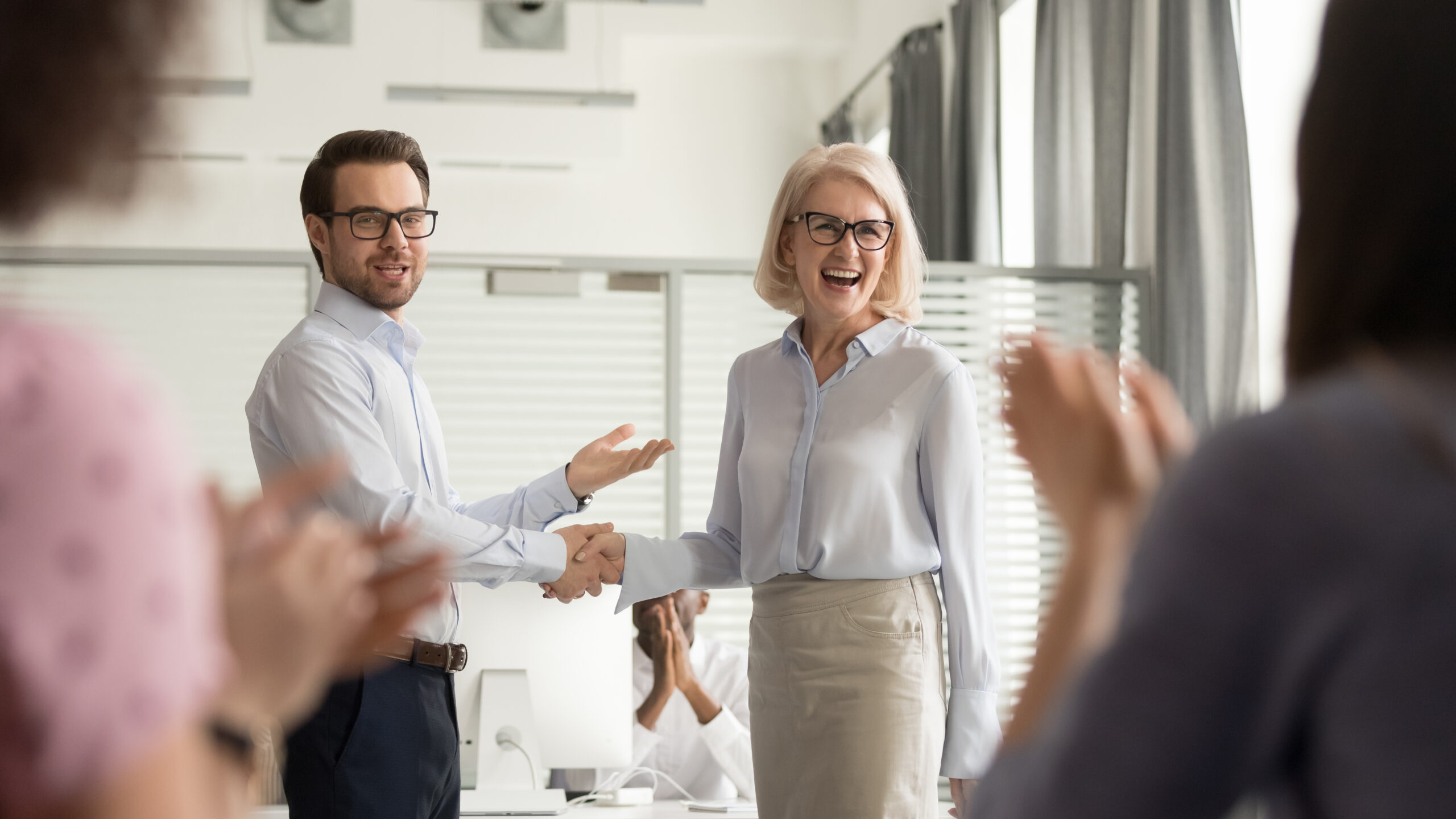 Happy CEO offering employee recognition to employee