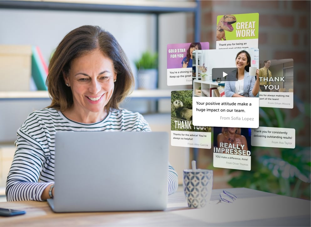 Woman smiles while using employee recognition software by Kudoboard