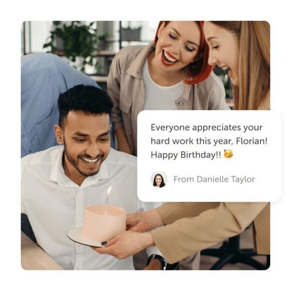 Office workers delivering cake with lit candle and an online birthday card from Kudoboard.
