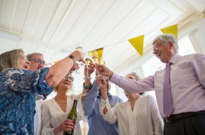 A group of older celebrants at a retirement farewell party, toasting.