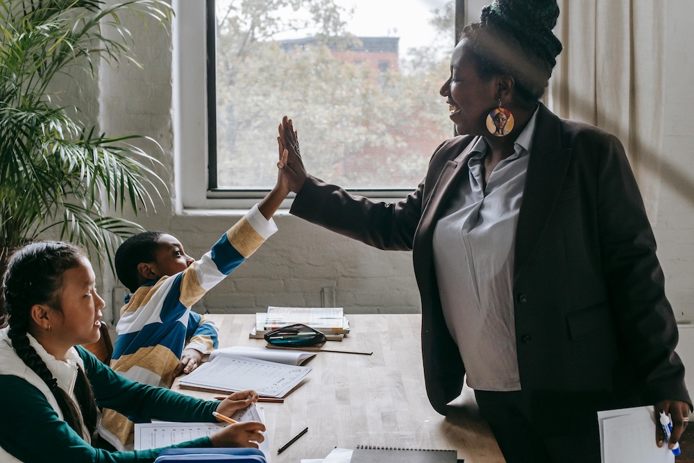 children giving their teacher a high-five, rather than an ecard