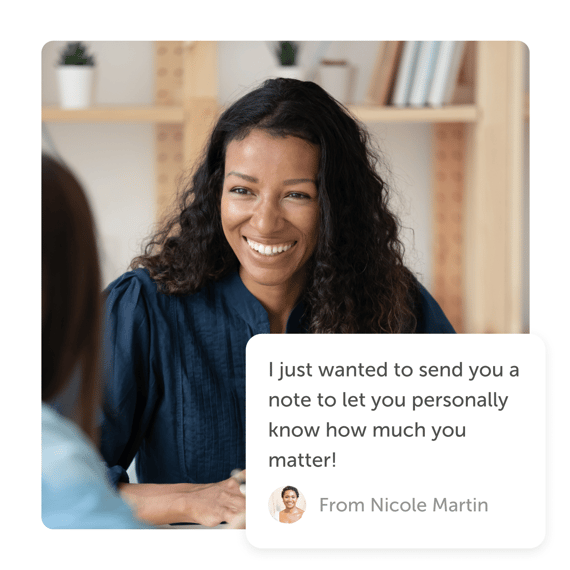 Woman smiling at coworker with an online thank you card by Kudoboard
